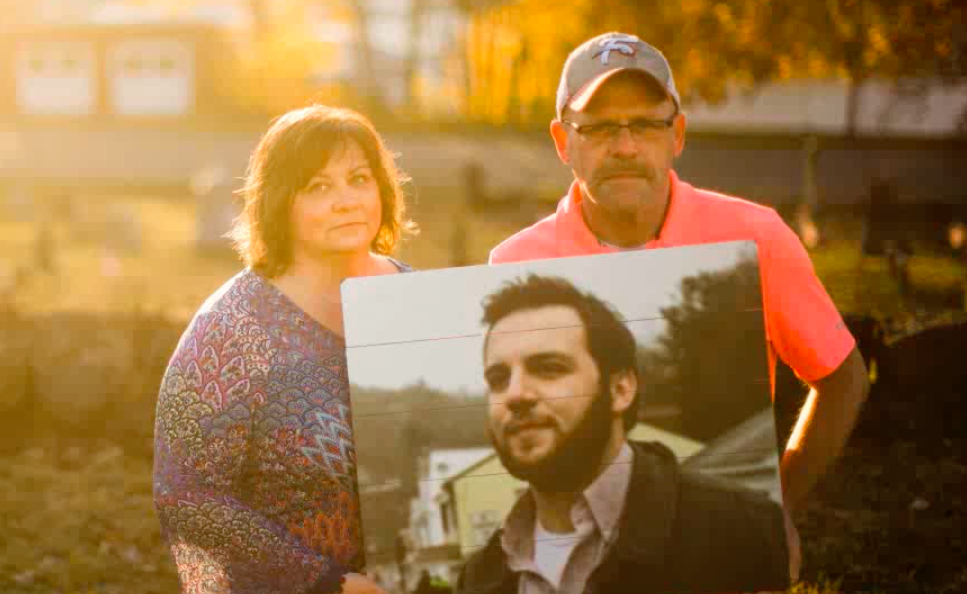parents of former Mayor Brandon Wentz holding his picture after his overdose death