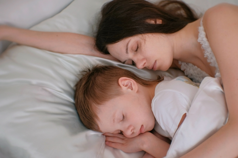 Mother and son sleep in bed, addicted mother