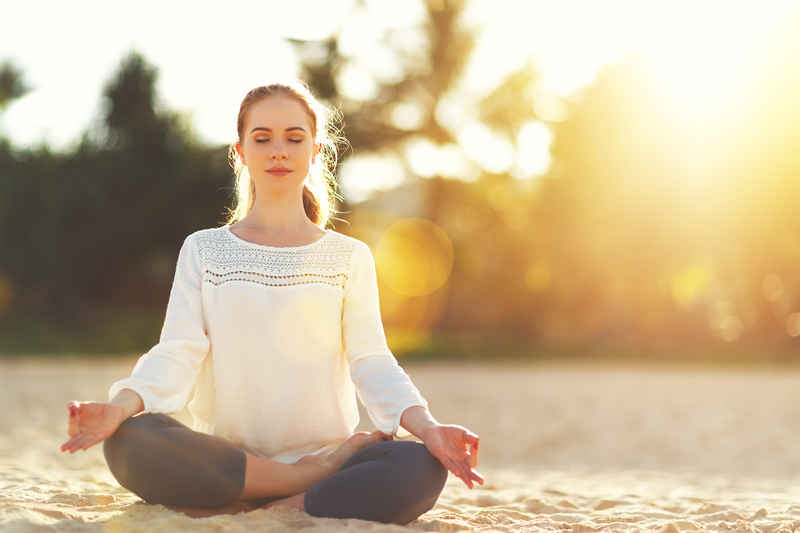 Woman doing yoga on the beach, fun in sobriety