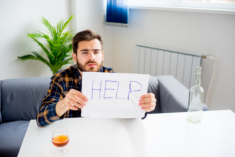 Man with alcohol and help sign, wants to know how to get sober