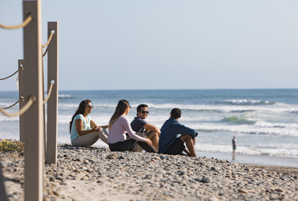 Young people sitting on the beach, getting treatment quickly