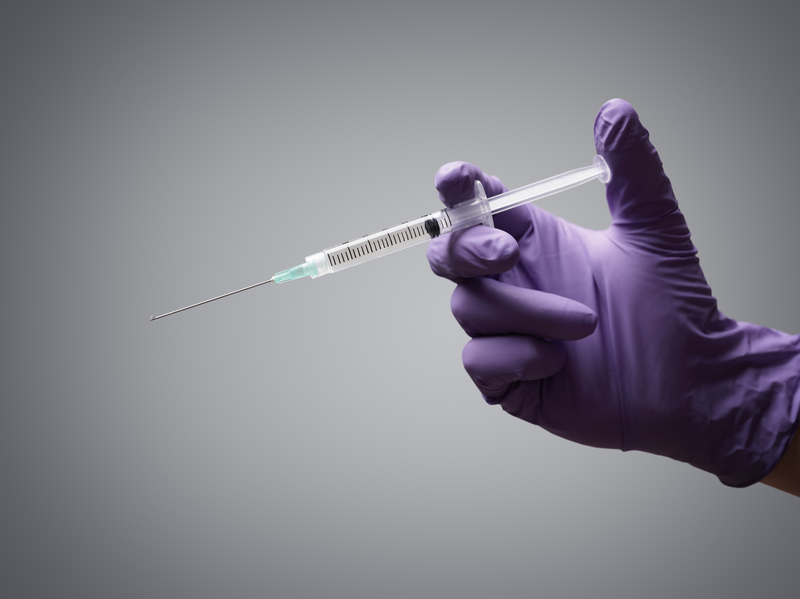 Gloved hand holding syringe, fentanyl, lethal injection