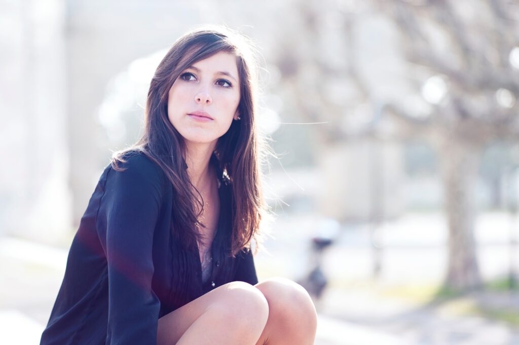Woman sitting, contemplating 12-step or SMART Recovery, powerlessness and choice