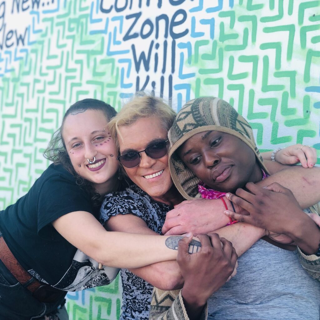 Gender Identity as a Foundation for Health 3 people at Inspire Recovery hugging and smiling