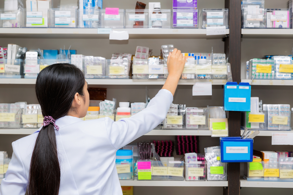 Pharmacist grabbing anti-diarrhea medication from the shelf