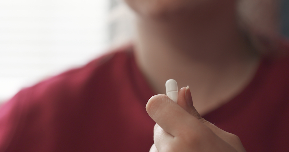 a young woman with opioid addiction taking a pill