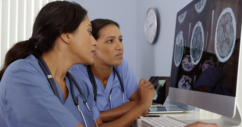 Two doctors reviewing brain scans, evidence for how AA works