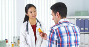 Doctor and patient discussing medication-assisted treatment, holding medication
