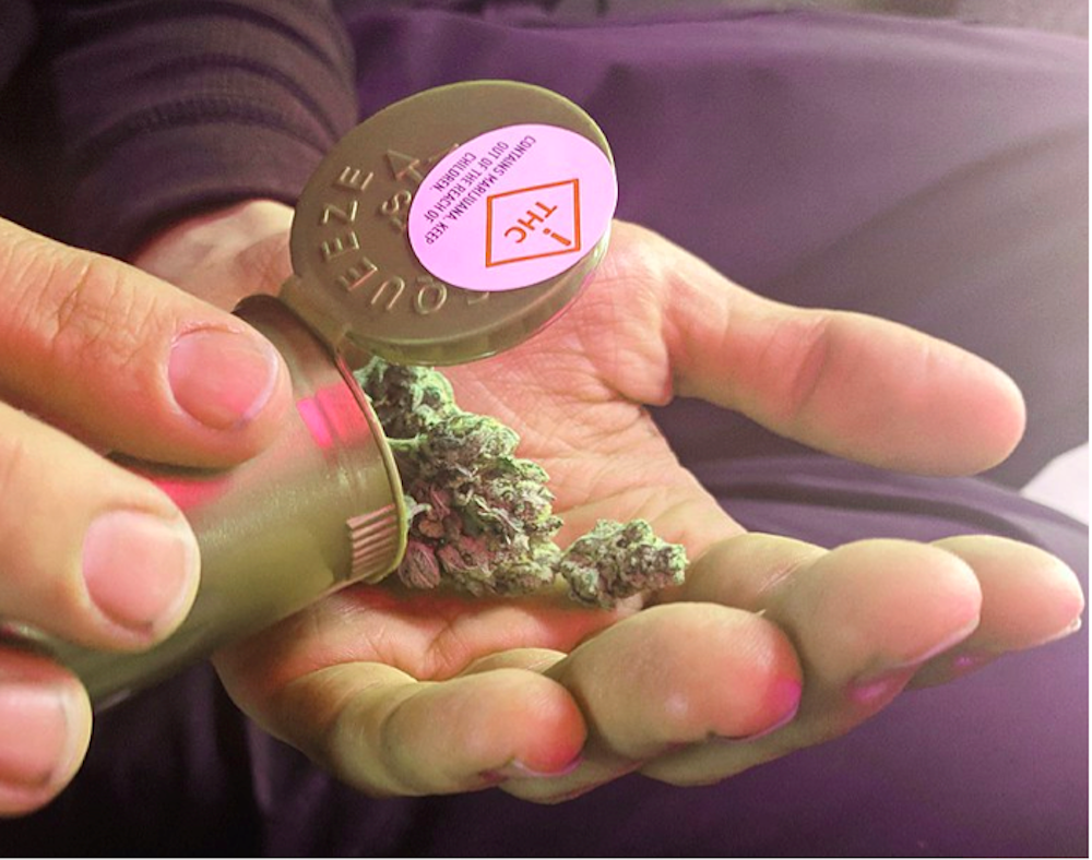 man holding container of medical marijuana