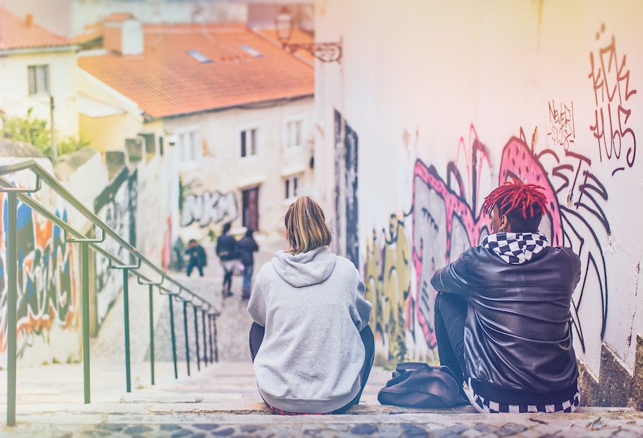 Two people sitting on steps, backs to the camera, practicing subversive, radical sobriety, counter-cultural movement