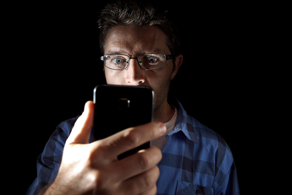 man with smartphone addiction staring at screen
