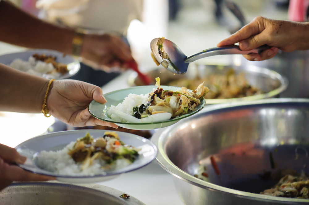 person serving food as part of a unique initiative