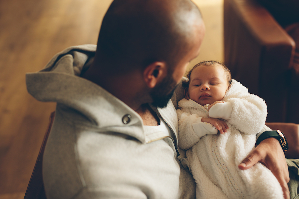 Dad with postpartum depression holding newborn