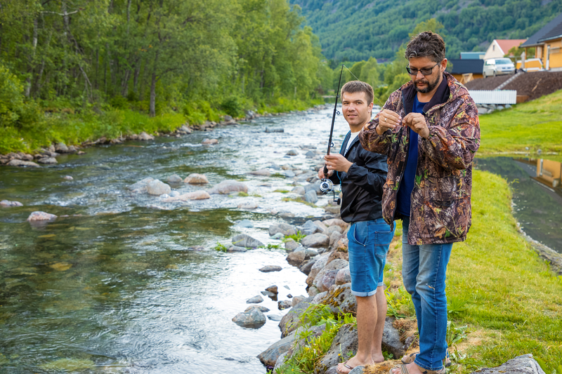 sober teen fly fishing with his father