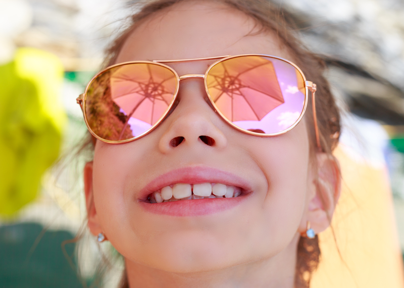 Happy, hopeful girl with sunglasses at the beach