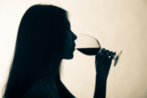 silhouette of woman drinking wine, drinking in recovery, non-abstinent