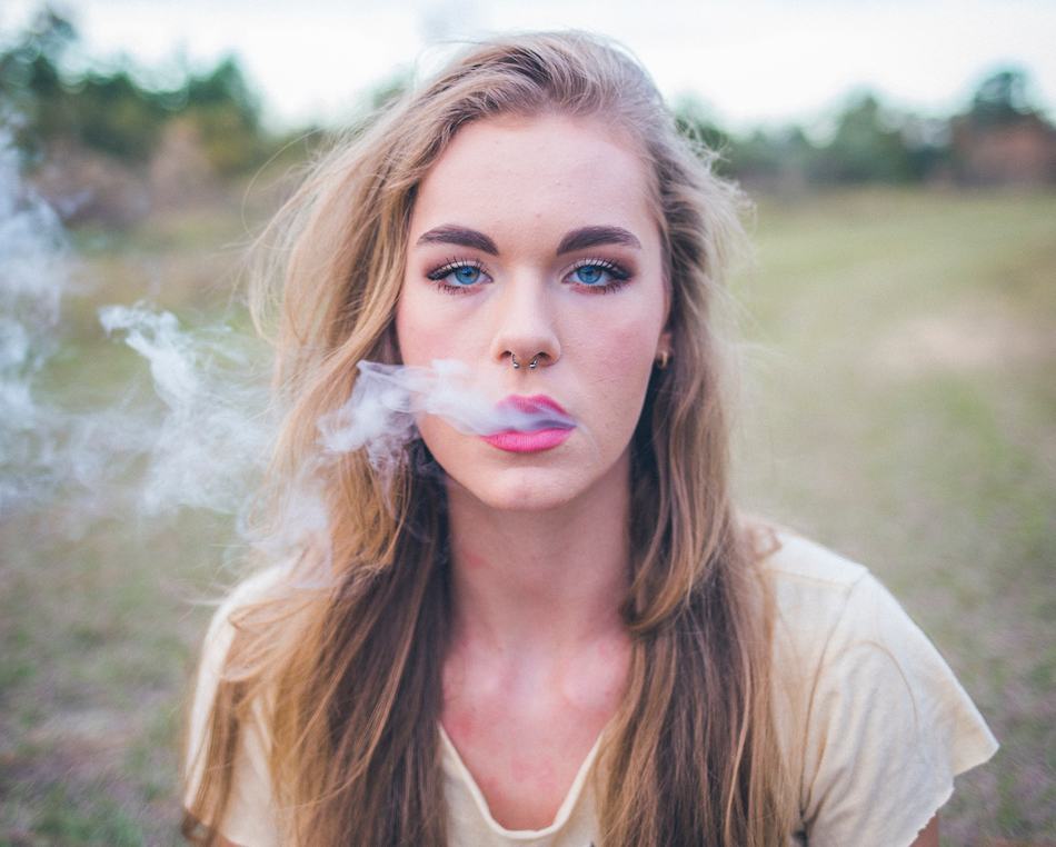 sober woman exhaling marijuana smoke