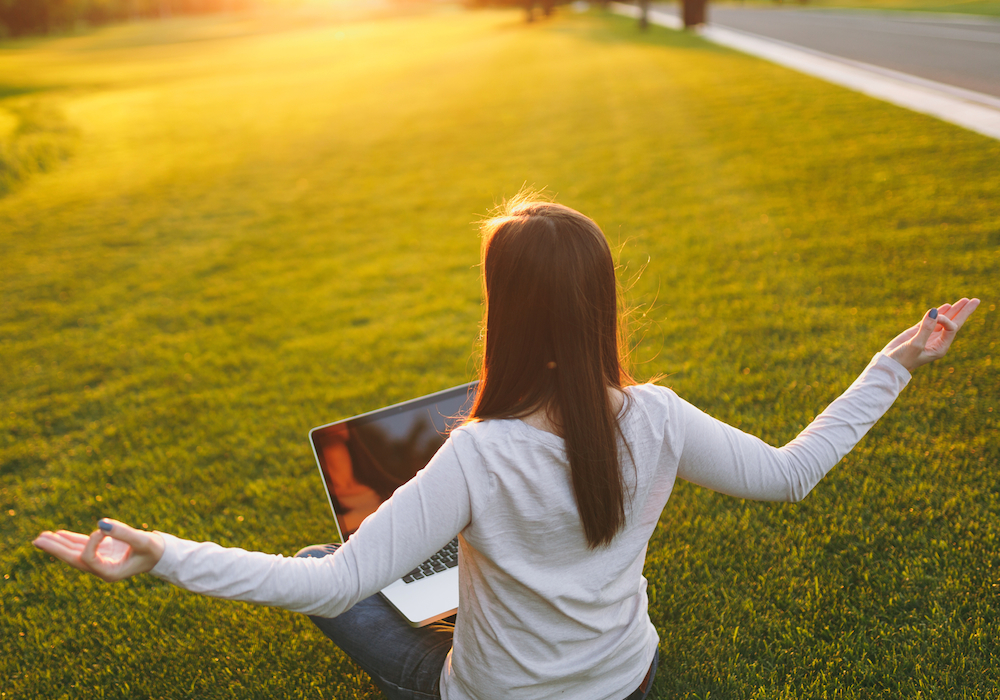 woman meditating with computer