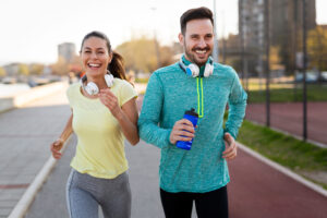 man and woman smiling and jogging