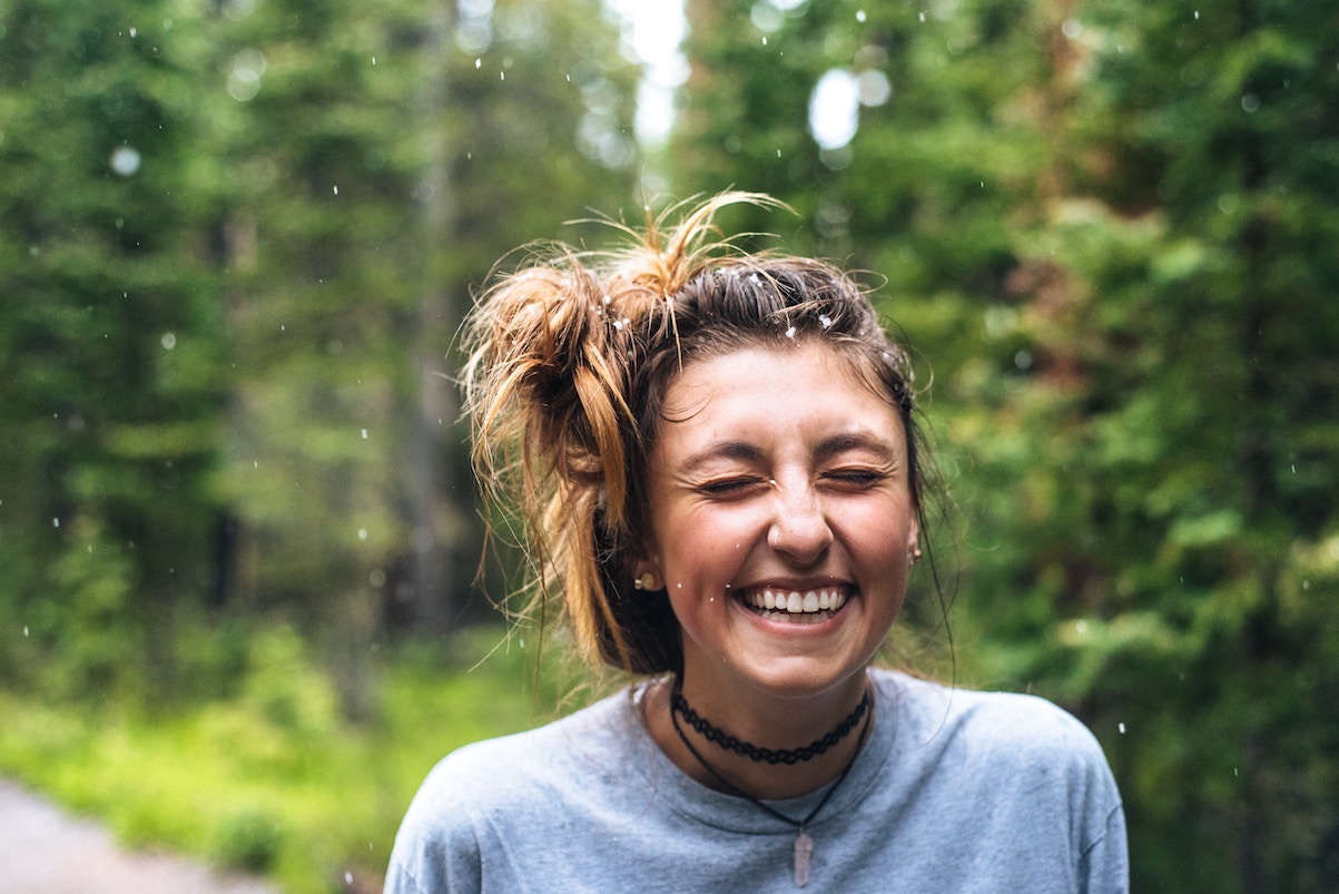 Woman smiling, eyes closed, in nature