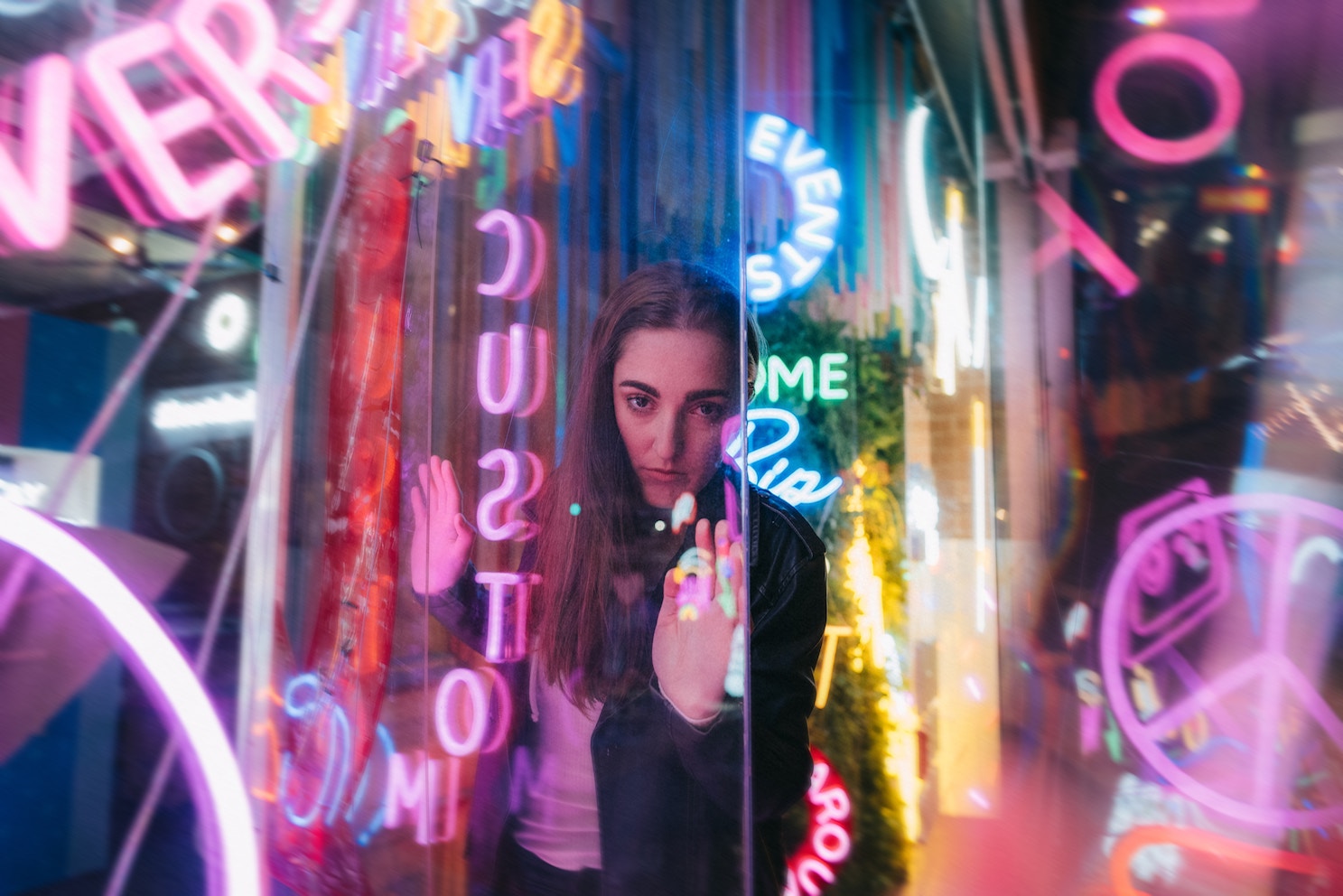 Woman staring at camera, standing among neon signs