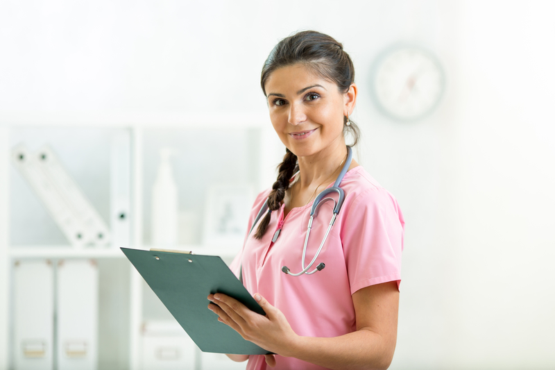 cheerful, female medical professional holding a clipboard