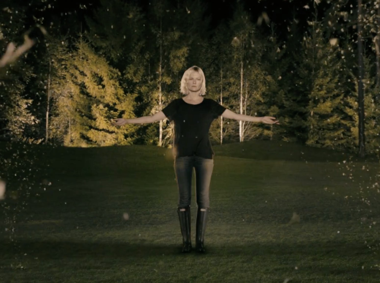Kirsten Dunst stands outdoors, arms outstretched, in "Melancholia"