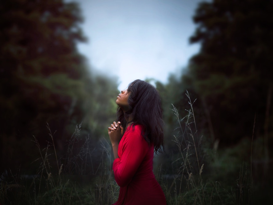 woman in red shirt praying