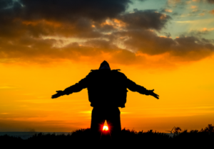 silhouette of man with outstretched arms at sunrise