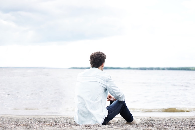 broken-hearted man sitting on beach