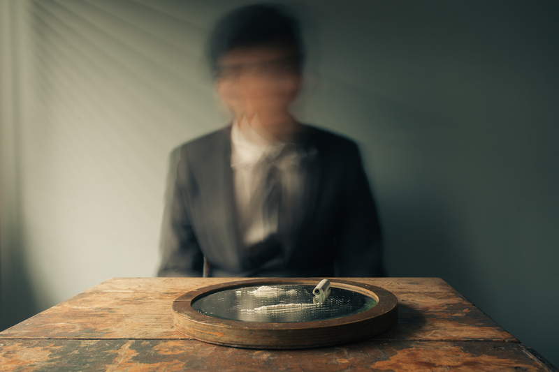 Out-of-focus man sitting at a table in front of a pile of white powder