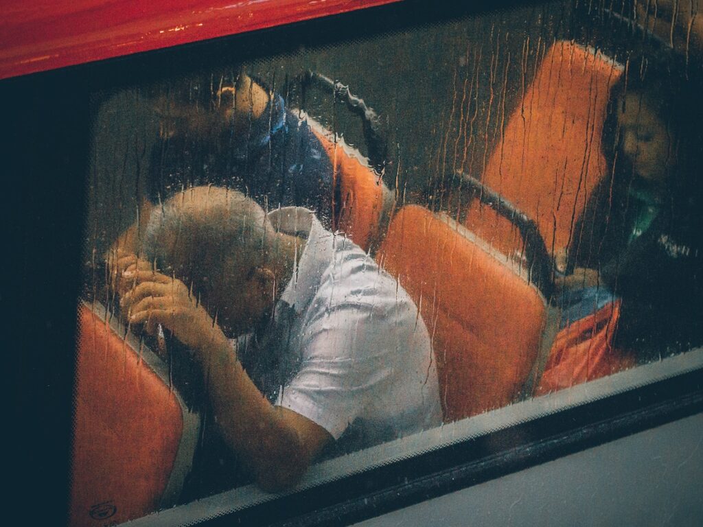 Upon Release from Prison, a New Kind of Nightmare Man on bus, head in hands against seat in front of him, despair