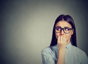 Woman biting her nails, nervous and craving.