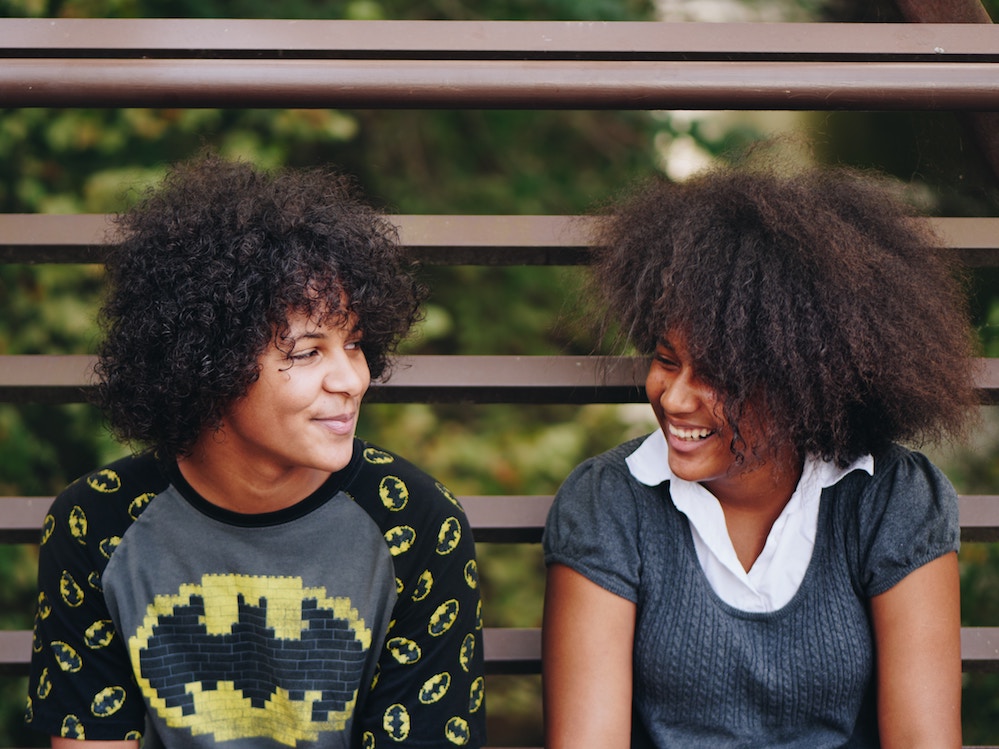two, young female family members smiling at each other