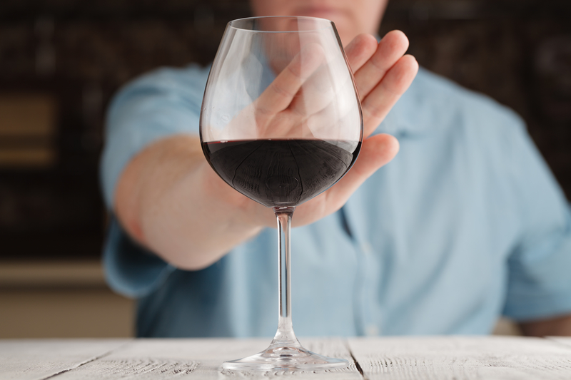 man refusing a glass or red wine during Dry January