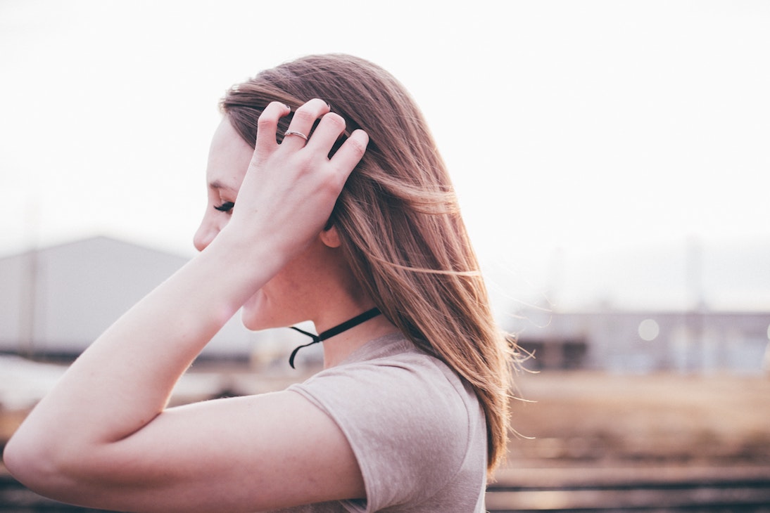 Side view of woman with hand in hair