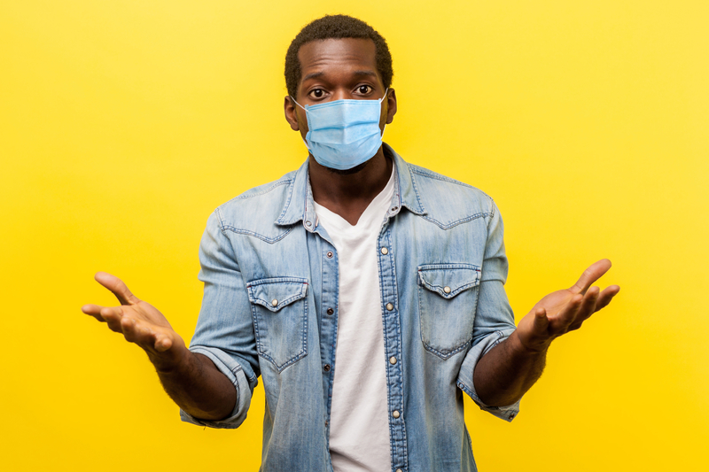 A man in a mask with outstretched arms and hands, confused