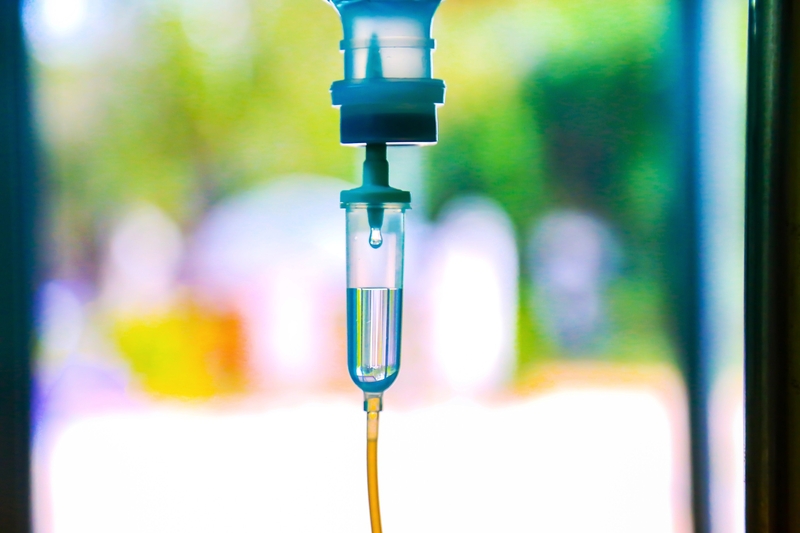 IV bag and fluid against colorful outdoor background