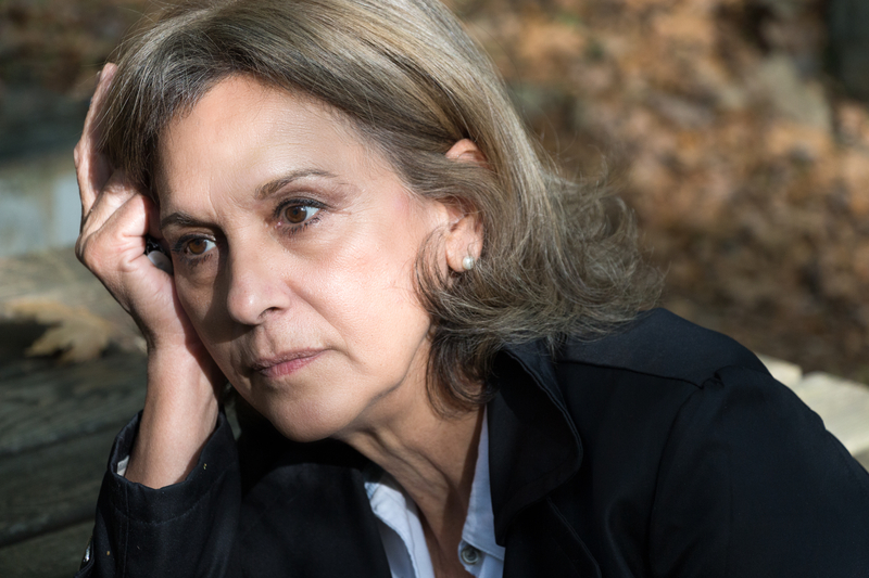 woman with head resting in hand, serious or sad