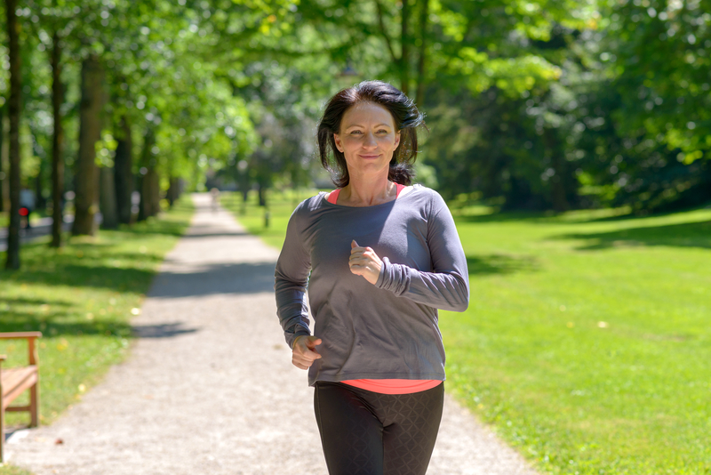 Woman jogging and smiling toward camera